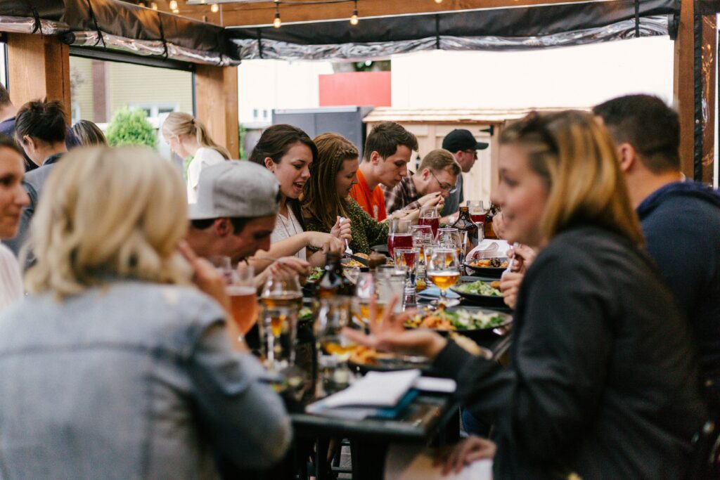 Group of friends sharing a meal at an outdoor restaurant patio