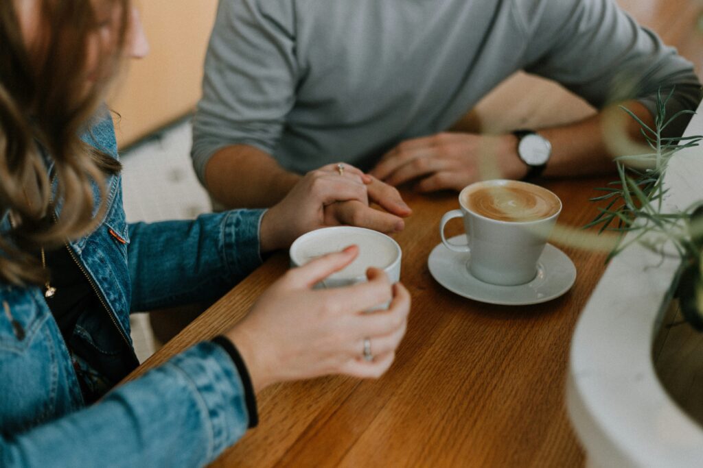 Couple holding hands over coffee at a café table