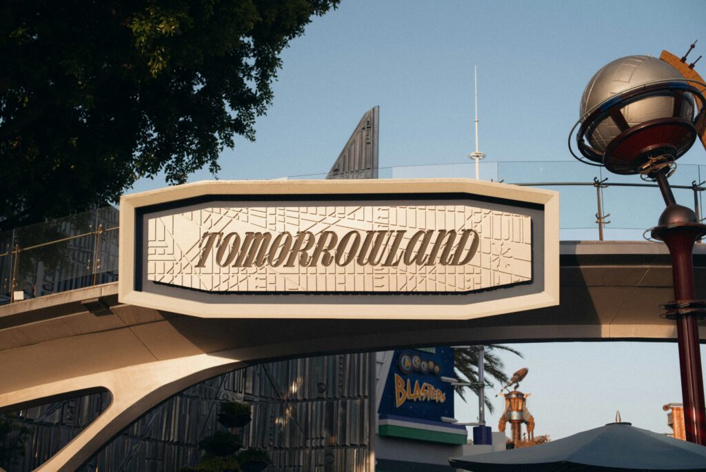 Close-up of the vintage-style Tomorrowland sign with geometric patterns under a clear sky, a famous landmark for festival visitors.