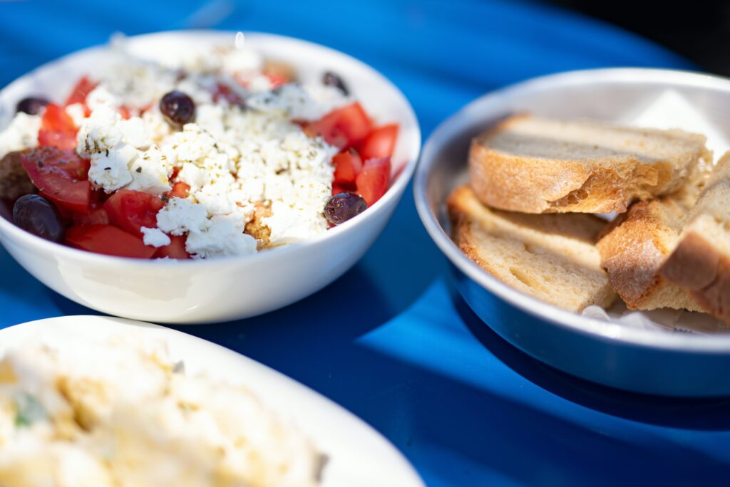 Traditional Greek village salad with feta, tomatoes and olives served with bread at an Athens taverna