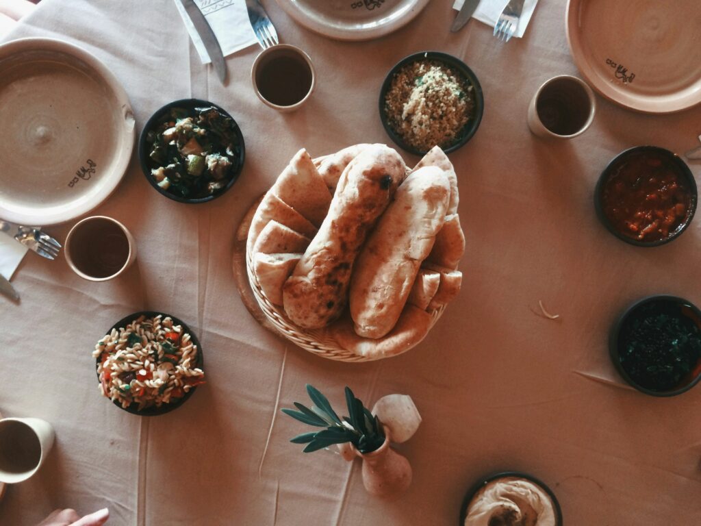 Overhead view of a mezze spread with flatbread, couscous and assorted dips on a table