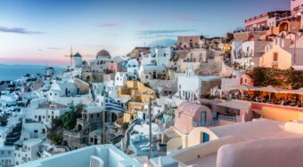 Whitewashed buildings and windmills of Oia village at sunset, Santorini, Greece