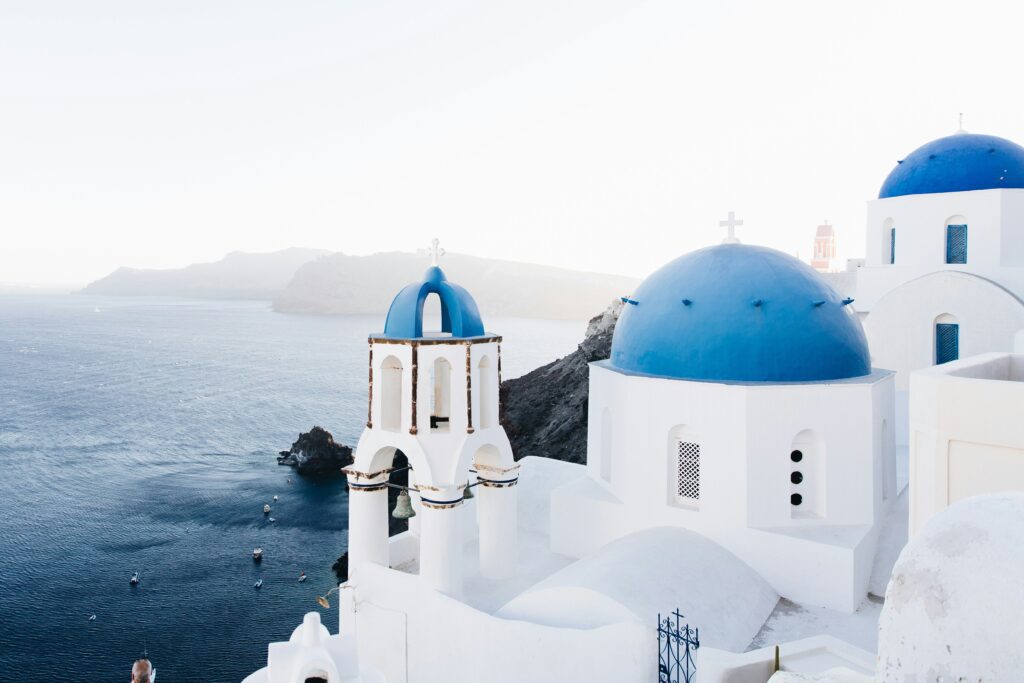 Iconic blue-domed churches and bell towers in Oia overlooking the Santorini caldera