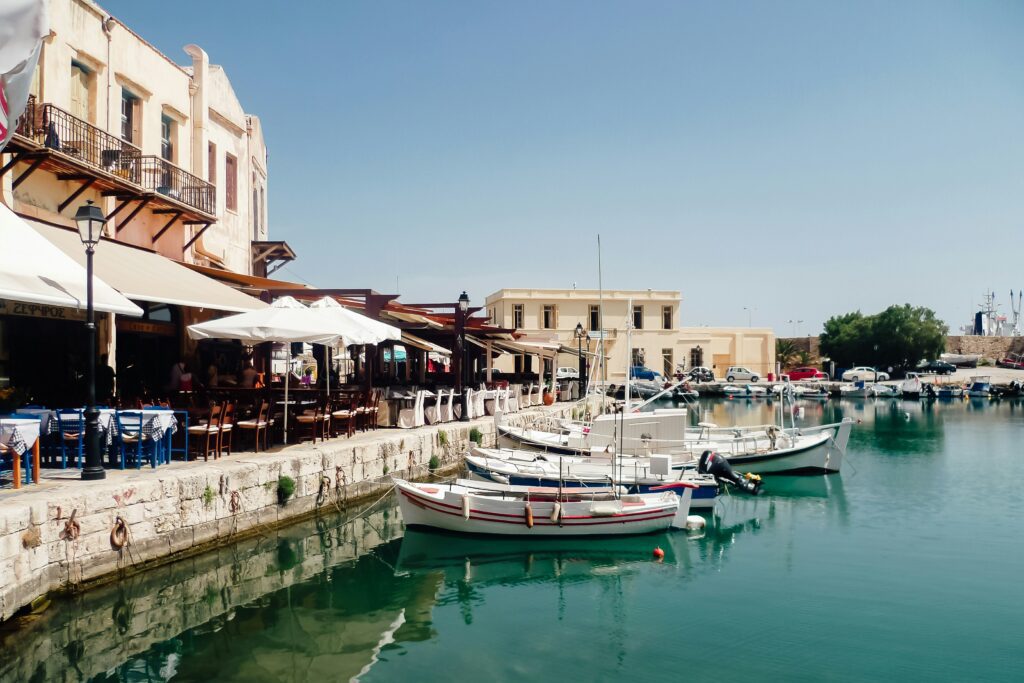 Traditional fishing boats moored at the Venetian harbour in Rethymno, Crete, with waterfront tavernas